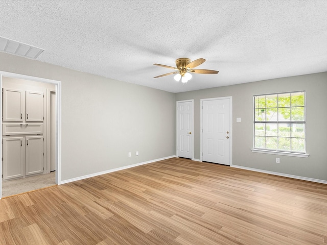 4704 Kristie Dr, Balch Springs, TX 75180 - empty room with a ceiling fan, light wood-style floors, baseboards, and a textured ceiling