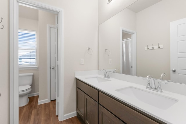 628 Hidden Cove Dr, Princeton, TX 75407 - full bath featuring toilet, wood finished floors, double vanity, and baseboards
