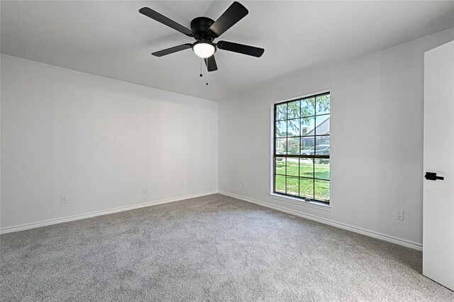 carpeted empty room featuring baseboards and ceiling fan