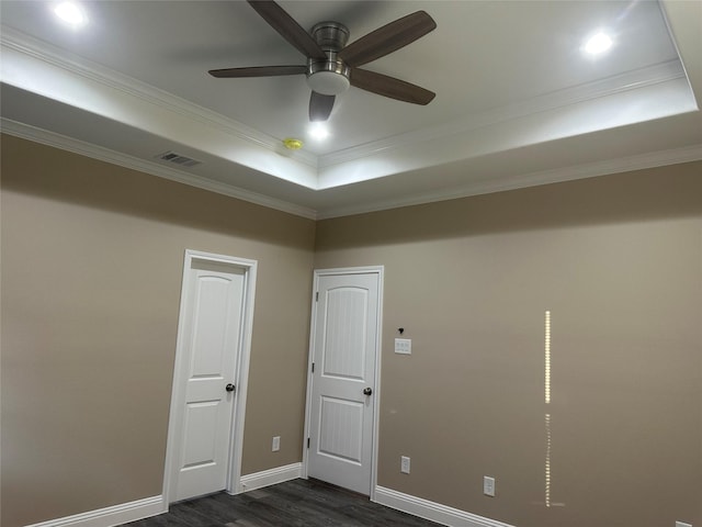 1009 S Preston St, Ennis, TX 75119 - empty room featuring dark wood-style floors, a raised ceiling, crown molding, baseboards, and a ceiling fan