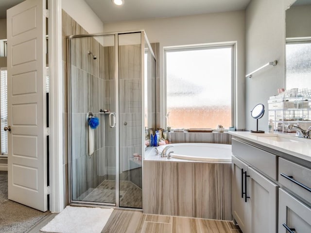 full bath with a stall shower, a garden tub, vanity, and recessed lighting