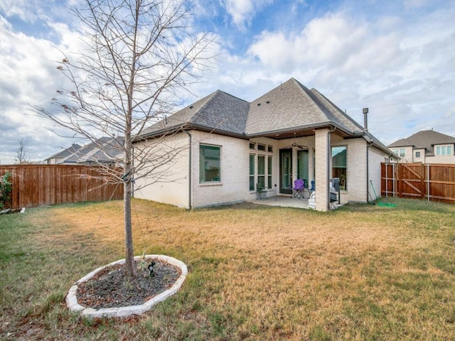 rear view of property featuring brick siding, a shingled roof, a patio, and ceiling fan