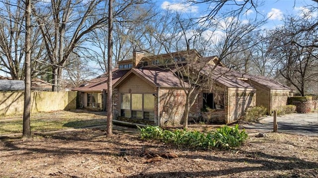 view of side of home with fence and brick siding