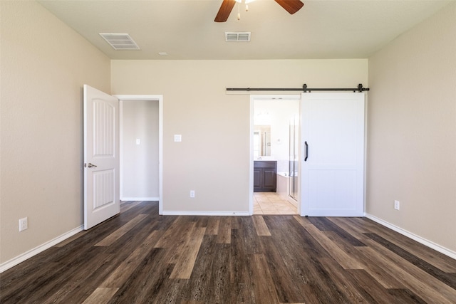 1004 Pierz Dr, Fort Worth, TX 76177 - unfurnished bedroom featuring wood finished floors, a barn door, baseboards, ensuite bath, and a ceiling fan