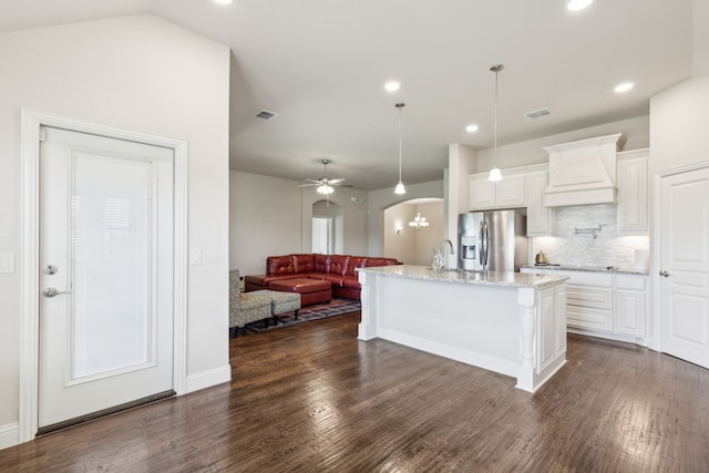 kitchen featuring stainless steel refrigerator with ice dispenser, custom range hood, white cabinets, backsplash, and recessed lighting