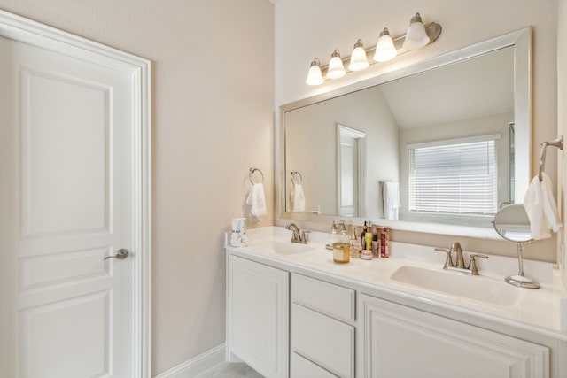 bathroom with double vanity and lofted ceiling