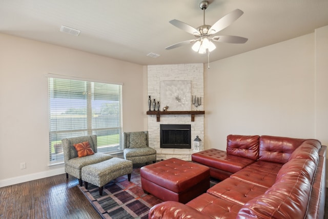 living area with wood finished floors, a ceiling fan, baseboards, and a fireplace