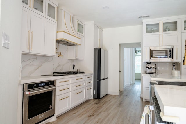 3221 Summerfield Dr, Richardson, TX 75082 - kitchen featuring appliances with stainless steel finishes, custom range hood, backsplash, and white cabinets