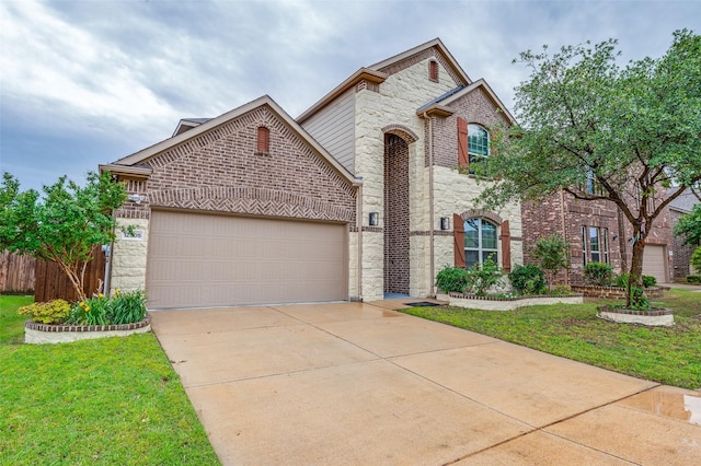 view of front of house featuring stone siding, an attached garage, driveway, brick siding, and a front lawn