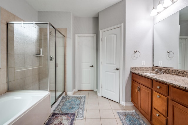 bathroom featuring a stall shower, tile patterned flooring, vanity, a garden tub, and baseboards
