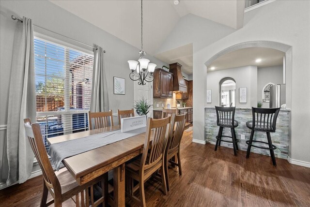 dining area featuring arched walkways, dark wood finished floors, a chandelier, baseboards, and high vaulted ceiling