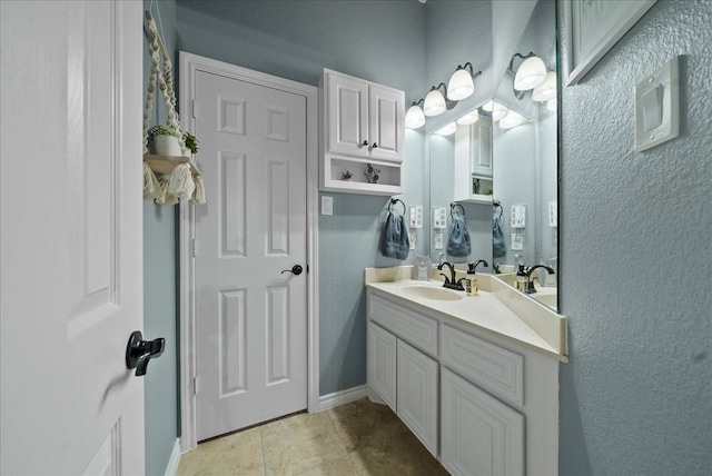 bathroom featuring vanity, baseboards, and a textured wall