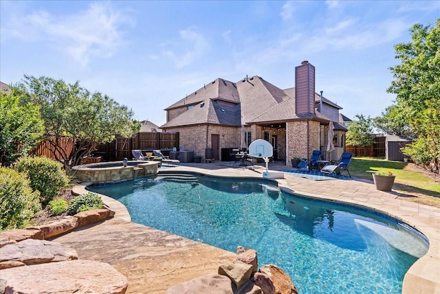 view of swimming pool featuring a patio area, a fenced backyard, and a pool with connected hot tub