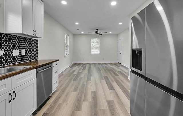 1713 Reuter Ave, Waco, TX 76708 - kitchen with appliances with stainless steel finishes, wooden counters, recessed lighting, tasteful backsplash, and white cabinetry