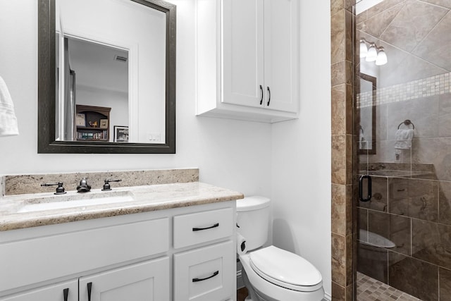 bathroom featuring vanity, a stall shower, and toilet