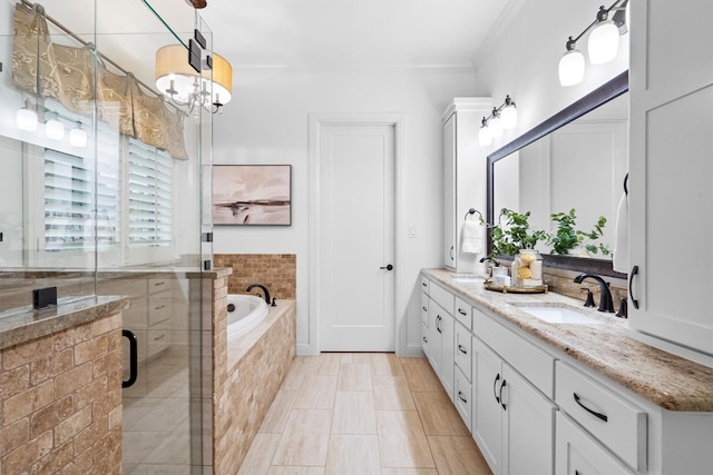 bathroom featuring crown molding, a shower stall, a garden tub, double vanity, and a chandelier