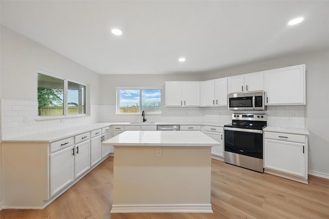 3169 Longbow Dr, Grand Prairie, TX 75052 - kitchen with appliances with stainless steel finishes, a sink, tasteful backsplash, light wood-type flooring, and recessed lighting