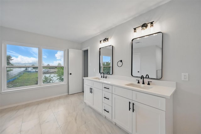 3169 Longbow Dr, Grand Prairie, TX 75052 - bathroom with plenty of natural light, marble look tile flooring, double vanity, and baseboards