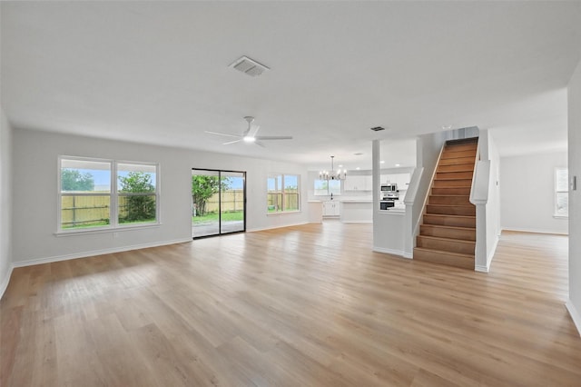 3169 Longbow Dr, Grand Prairie, TX 75052 - unfurnished living room featuring ceiling fan, a chandelier, baseboards, stairway, and light wood-style floors