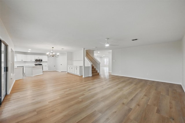 3169 Longbow Dr, Grand Prairie, TX 75052 - unfurnished living room featuring a chandelier, a ceiling fan, light wood-style flooring, and baseboards