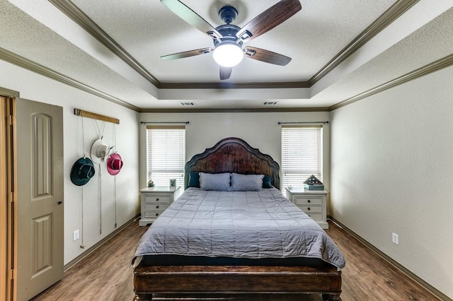 870 1st St, Maypearl, TX 76064 - bedroom featuring a tray ceiling, wood finished floors, a textured ceiling, ornamental molding, and a ceiling fan