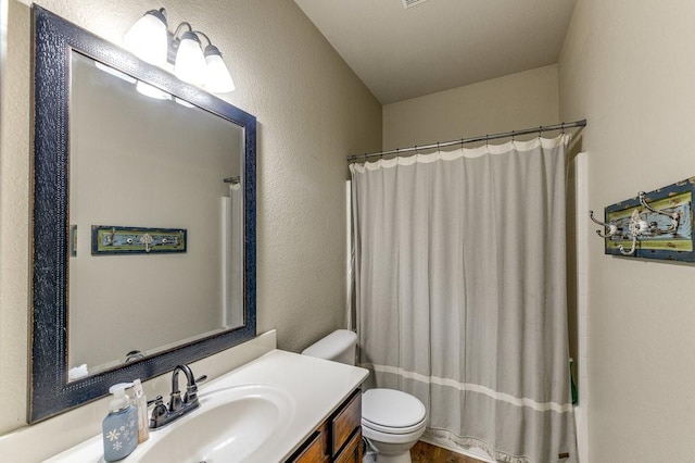 870 1st St, Maypearl, TX 76064 - full bathroom with toilet, vanity, a shower with curtain, and a textured wall