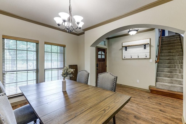 870 1st St, Maypearl, TX 76064 - unfurnished dining area featuring arched walkways, a chandelier, crown molding, wood finished floors, and stairway