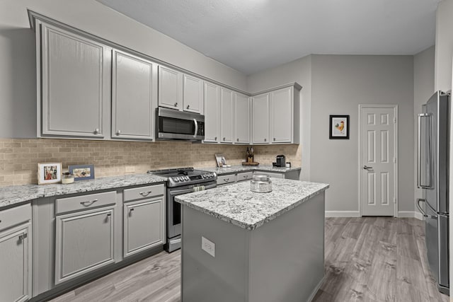 4719 Highlands Dr, Mckinney, TX 75070 - kitchen with appliances with stainless steel finishes, gray cabinetry, and light wood-style flooring