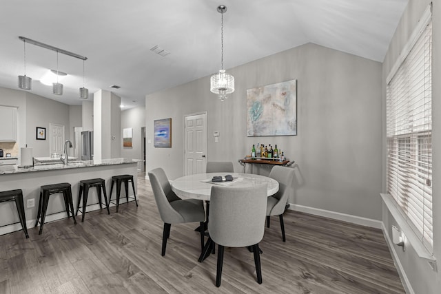 4719 Highlands Dr, Mckinney, TX 75070 - dining area with wood finished floors, baseboards, and vaulted ceiling