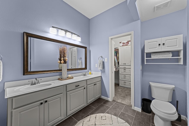 4719 Highlands Dr, Mckinney, TX 75070 - bathroom featuring toilet, tile patterned flooring, double vanity, a spacious closet, and baseboards