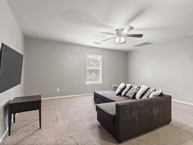 living room with light colored carpet, a ceiling fan, and baseboards
