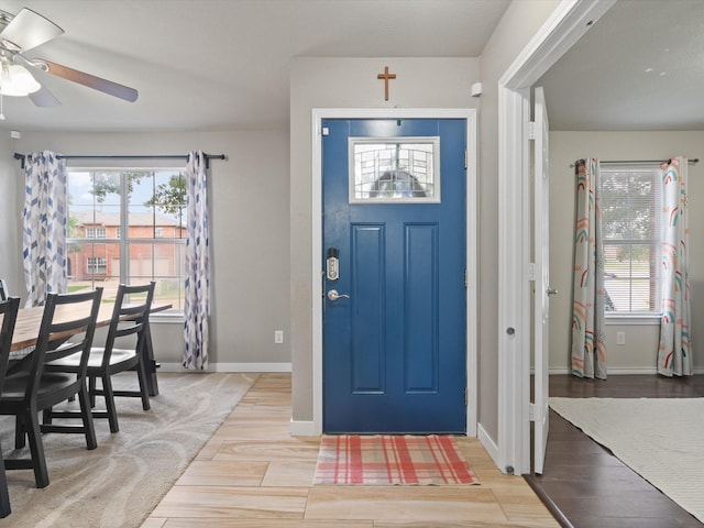 foyer entrance featuring wood finished floors, plenty of natural light, ceiling fan, and baseboards