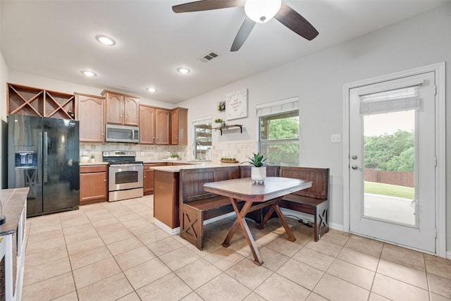 5221 Buckthorn Dr, Mckinney, TX 75071 - kitchen with stainless steel appliances, decorative backsplash, light tile patterned flooring, ceiling fan, and recessed lighting