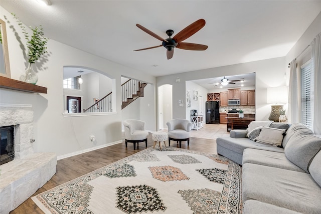 5221 Buckthorn Dr, Mckinney, TX 75071 - living area featuring a ceiling fan, arched walkways, and light wood finished floors