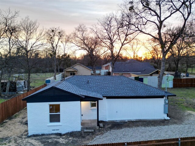 4205 Humphrey Dr, Dallas, TX 75216 - rear view of property with brick siding, fence, and a shingled roof
