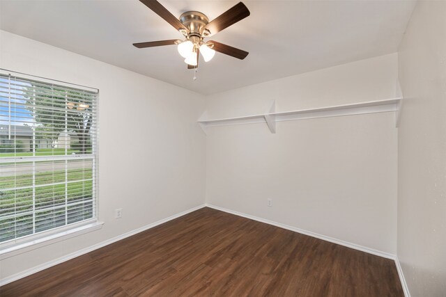 empty room featuring wood finished floors, baseboards, and ceiling fan