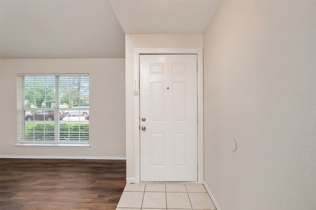 doorway featuring baseboards and wood finished floors
