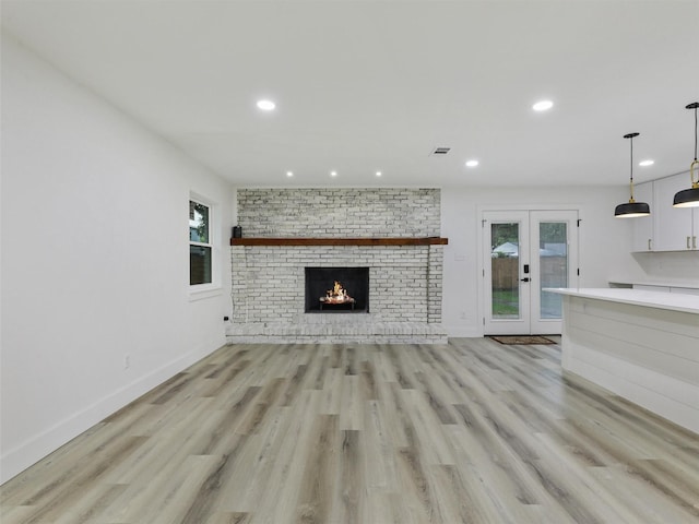 737 Finland St, Grand Prairie, TX 75050 - unfurnished living room with french doors, light wood finished floors, recessed lighting, baseboards, and a fireplace