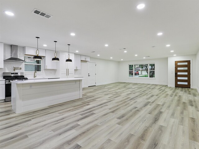 737 Finland St, Grand Prairie, TX 75050 - kitchen featuring wall chimney exhaust hood, stainless steel electric range, light wood-style flooring, recessed lighting, and light countertops