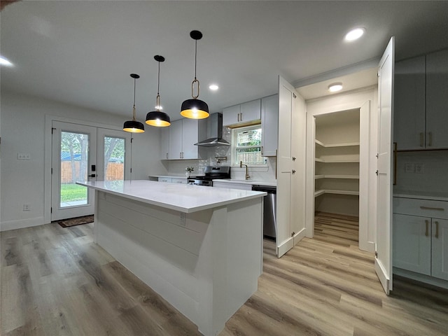 737 Finland St, Grand Prairie, TX 75050 - kitchen featuring stainless steel appliances, wall chimney range hood, light countertops, light wood finished floors, and recessed lighting