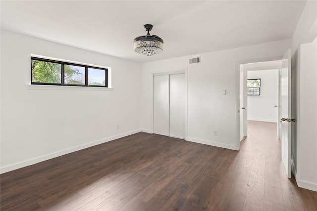 5726 Enchanted Ln, Dallas, TX 75227 - unfurnished bedroom with dark wood-style floors, baseboards, and a closet