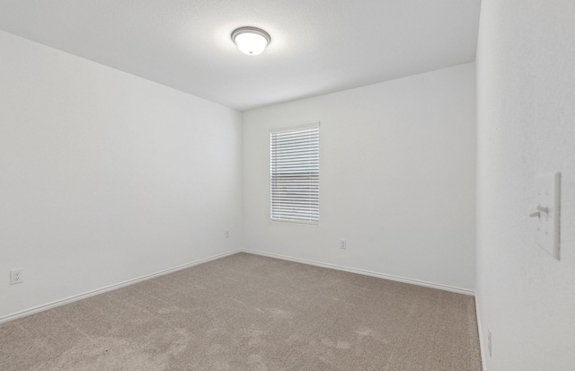 carpeted empty room with baseboards