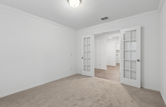 unfurnished bedroom with french doors, crown molding, carpet floors, and baseboards