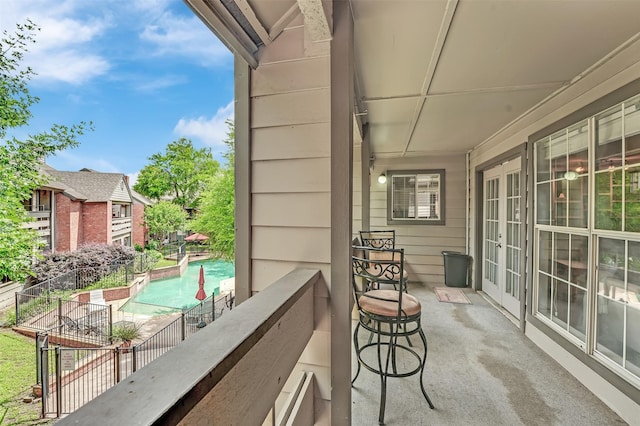balcony with french doors and view of pool