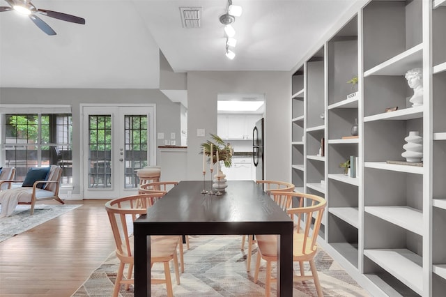 dining area featuring a ceiling fan, light wood finished floors, and track lighting