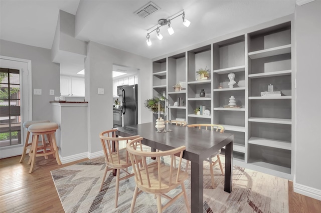 dining area with baseboards and light wood-type flooring