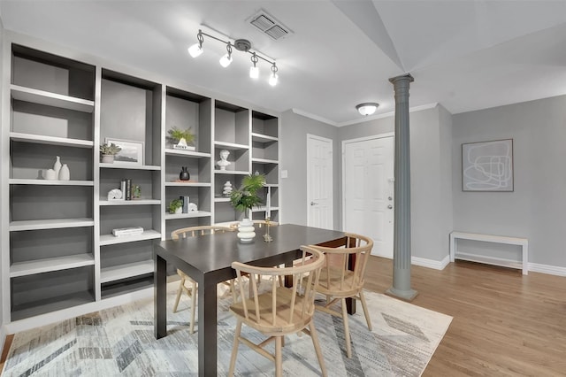 dining space with decorative columns, baseboards, light wood-type flooring, and crown molding