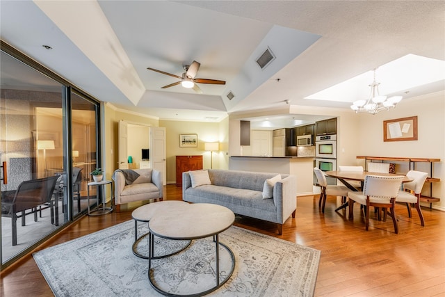 5909 Luther Ln Unit 1700, Dallas, TX 75225 - living area featuring a raised ceiling, wood finished floors, a ceiling fan, a chandelier, and baseboards