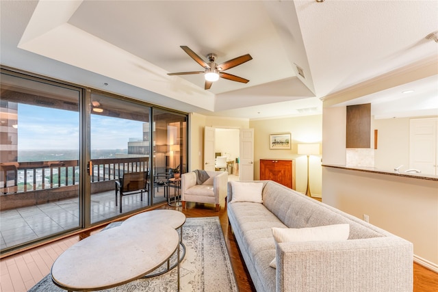 5909 Luther Ln Unit 1700, Dallas, TX 75225 - living area with ceiling fan, a tray ceiling, and wood finished floors