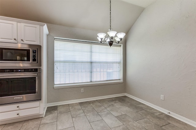 kitchen with stainless steel appliances, a chandelier, lofted ceiling, white cabinetry, and pendant lighting